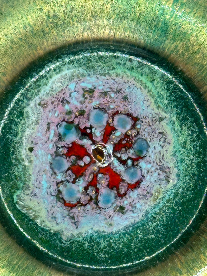 Close-up of Doris Hall petite dish center, red starburst with pale-blue dots around a central bead