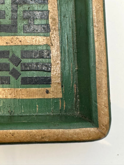 Corner detail of green wood tray showing geometric border and worn gilt edge