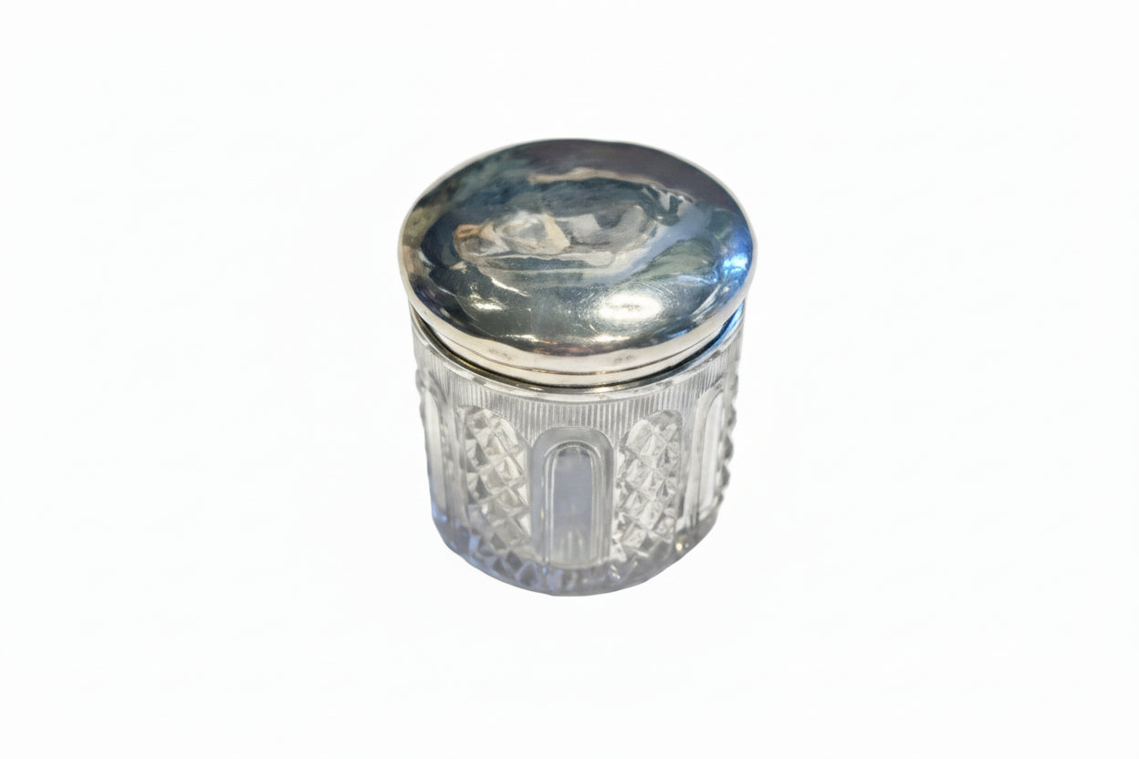 Vintage cut glass and sterling silver vanity jar, closed with domed silver lid and diamond-cut glass body.