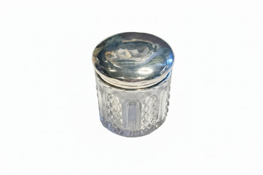 Vintage cut glass and sterling silver vanity jar, closed with domed silver lid and diamond-cut glass body.