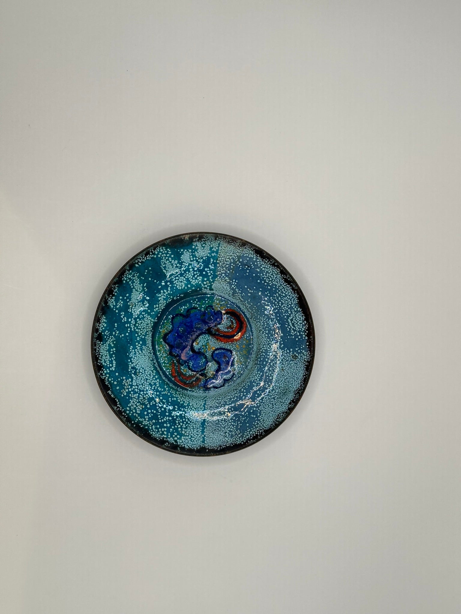 Doris Hall turquoise enamel dish, top view of cobalt-blue and red abstract swirl center