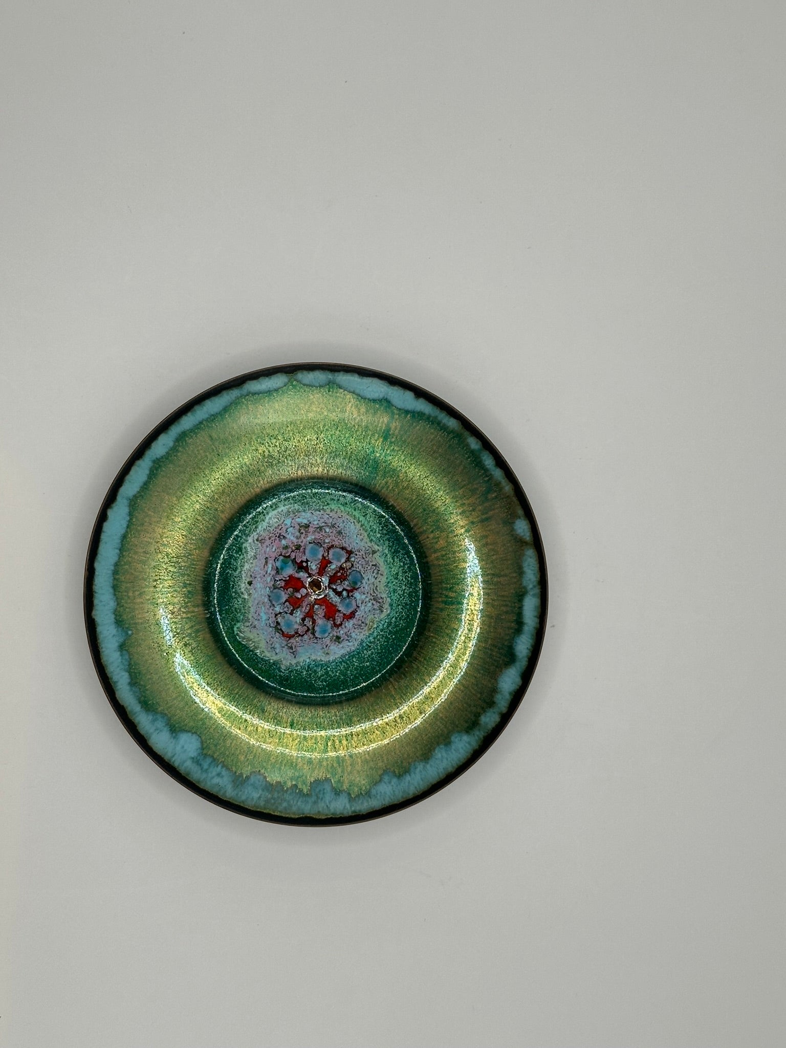 Doris Hall petite green enamel-on-copper dish, overhead view of red floral starburst center