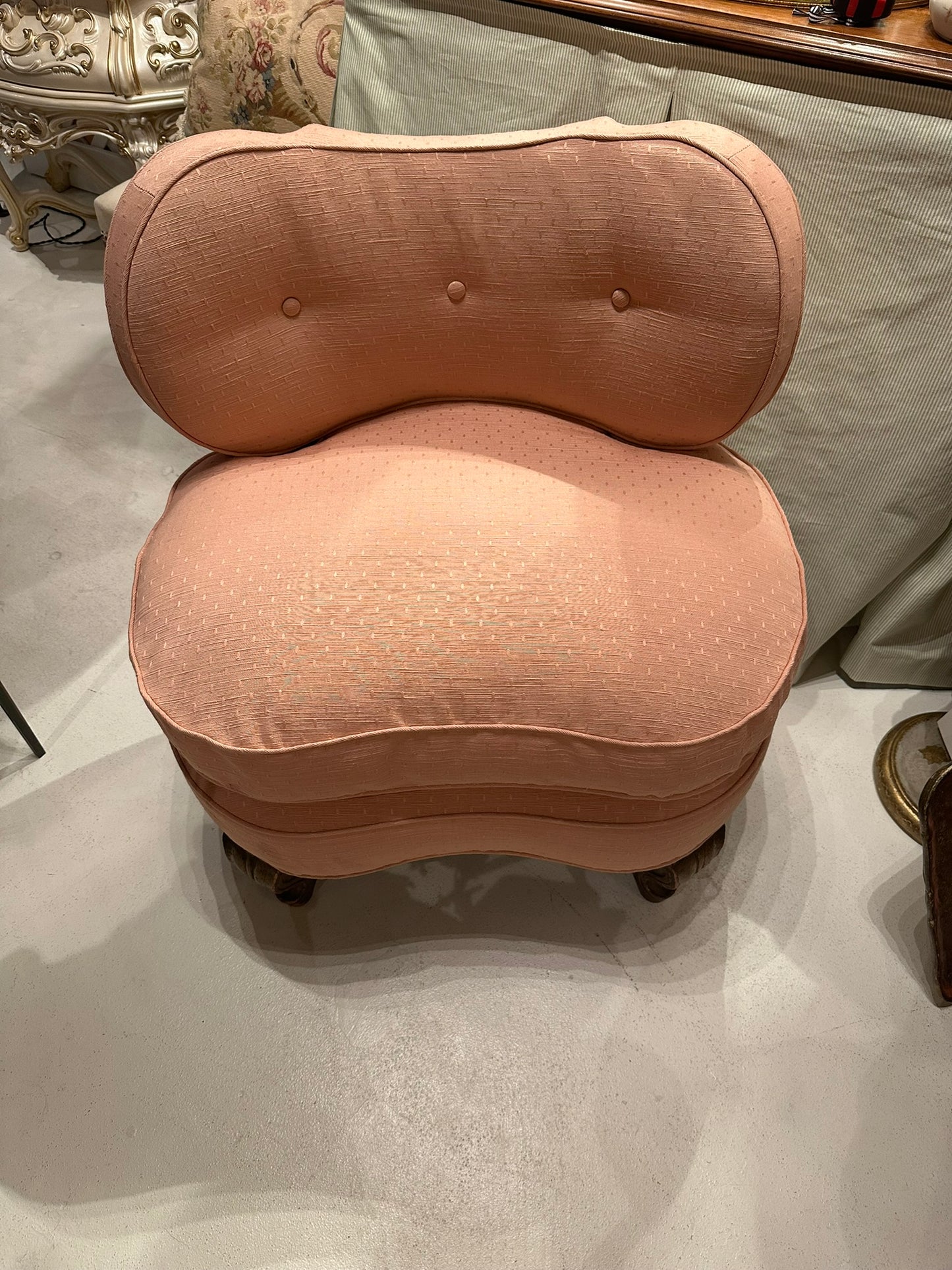 Antique pink coral boudoir chair, frontal view of buttoned back and plump seat cushion