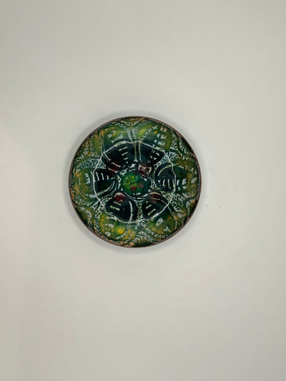 Overhead view of Doris Hall enamel dish, symmetrical green floral pattern with copper rim