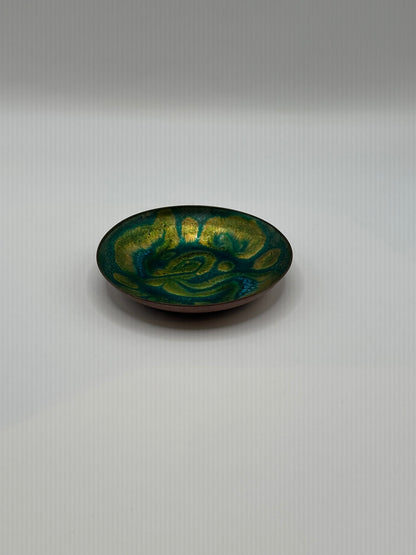 Doris Hall small green enamel dish, angled view of green-yellow swirl glaze with copper rim