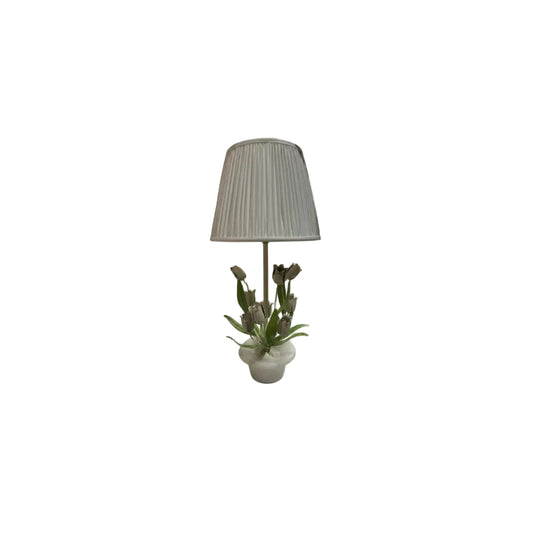 Vintage tole tulip and alabaster lamp with white pleated shade among other lamps on a white shelf