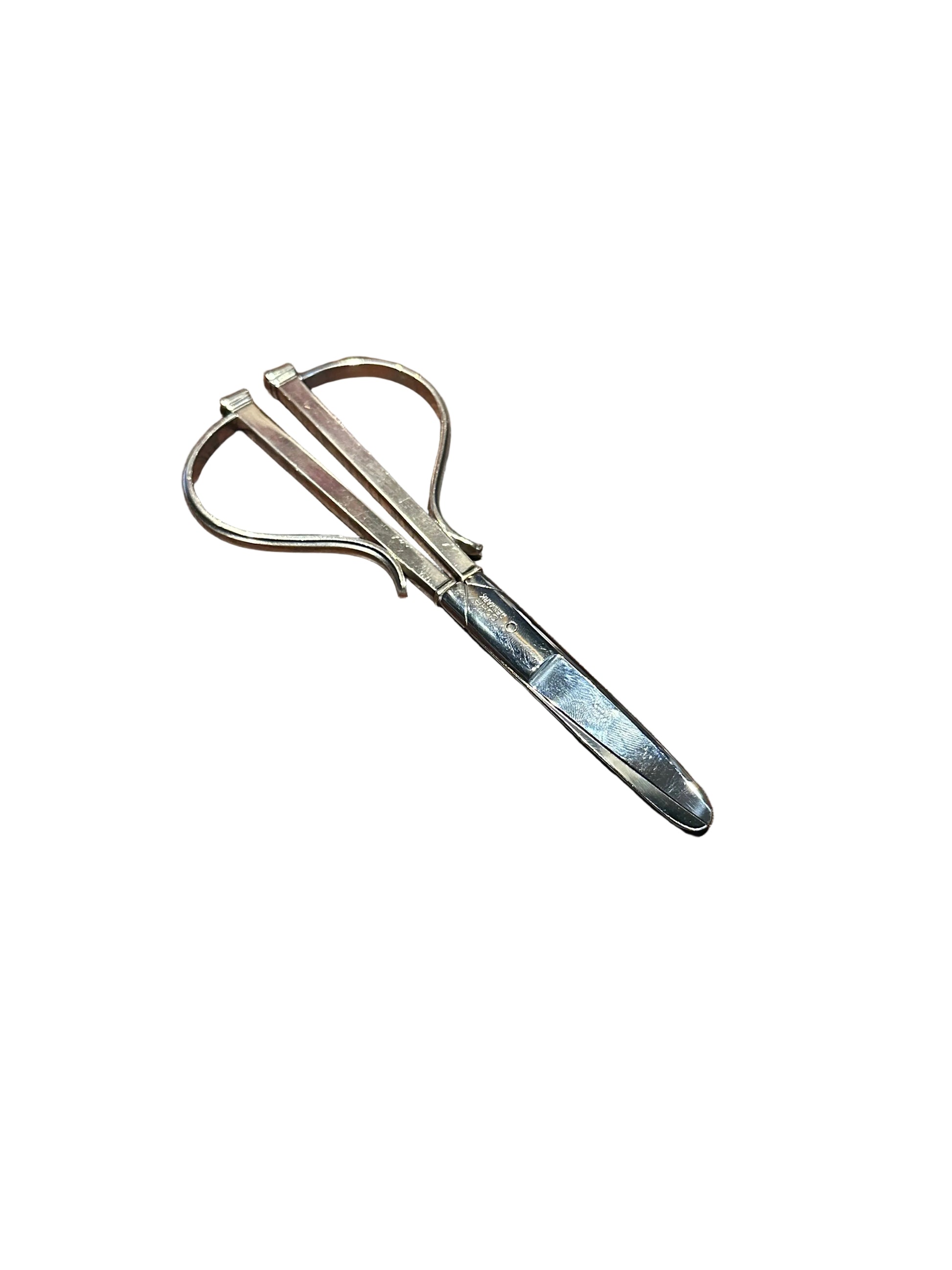 Cohr sterling grape shears resting at an angle, looped handles open and blades crossed