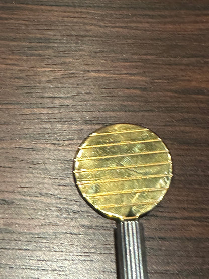 Close-up of the gilded round paddle of the Petrossian caviar spoon