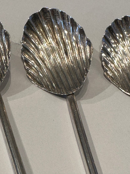 Close-up of two sterling silver shell-shaped sipper bowls