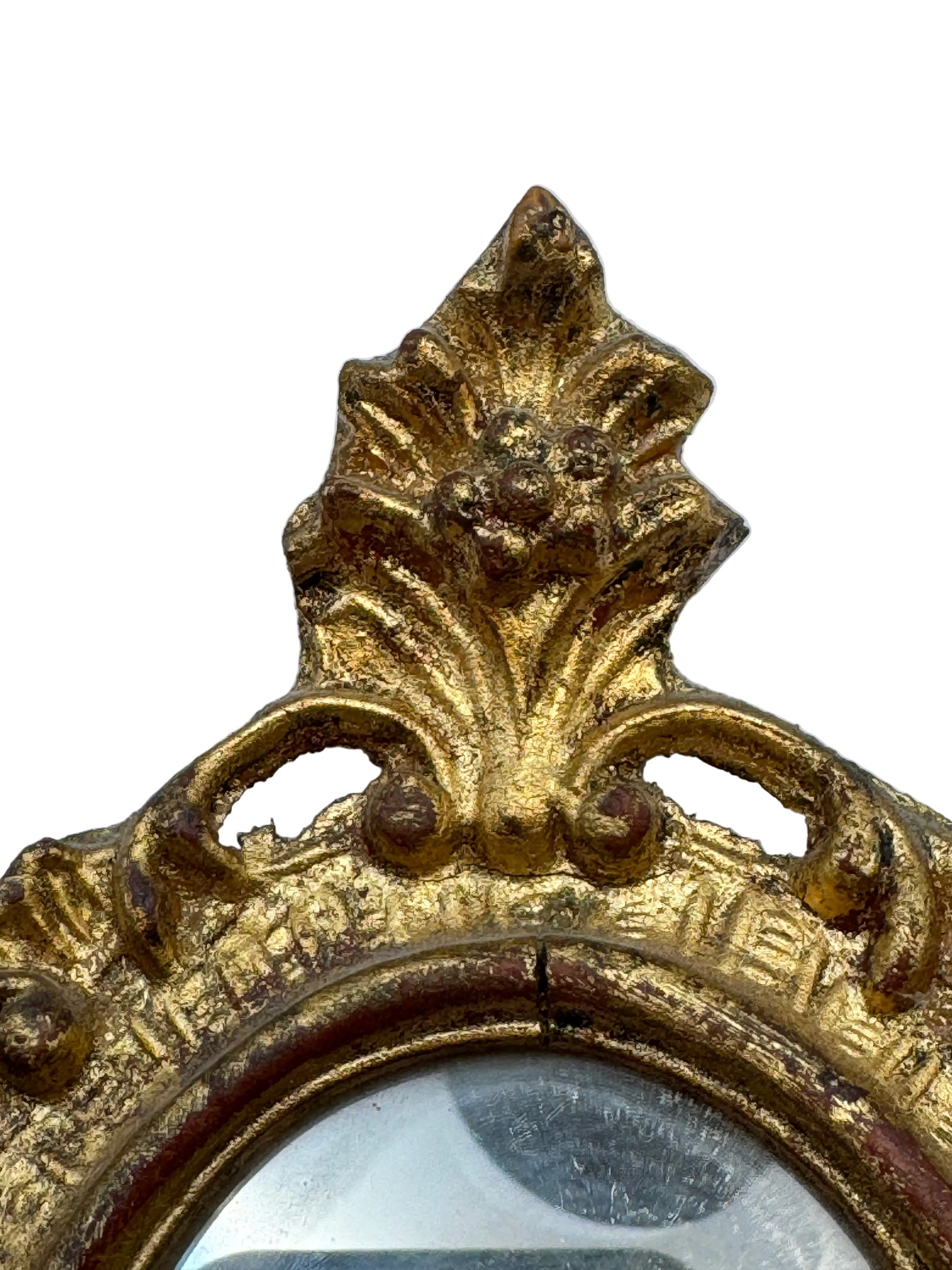 Close-up of the carved gilt acanthus crest atop the Florentine mirror frame.