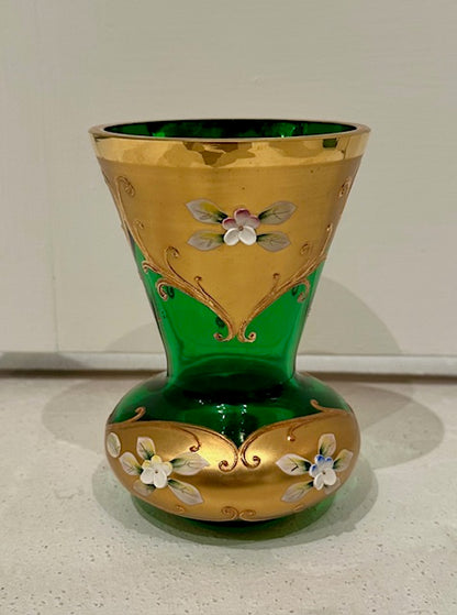 Emerald green Bohemian glass vase with gilt and enamel floral decoration, on a countertop