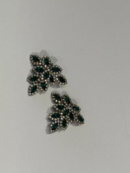 Vintage Les Bernard emerald and rhinestone leaf earrings, staggered pair, angled view.