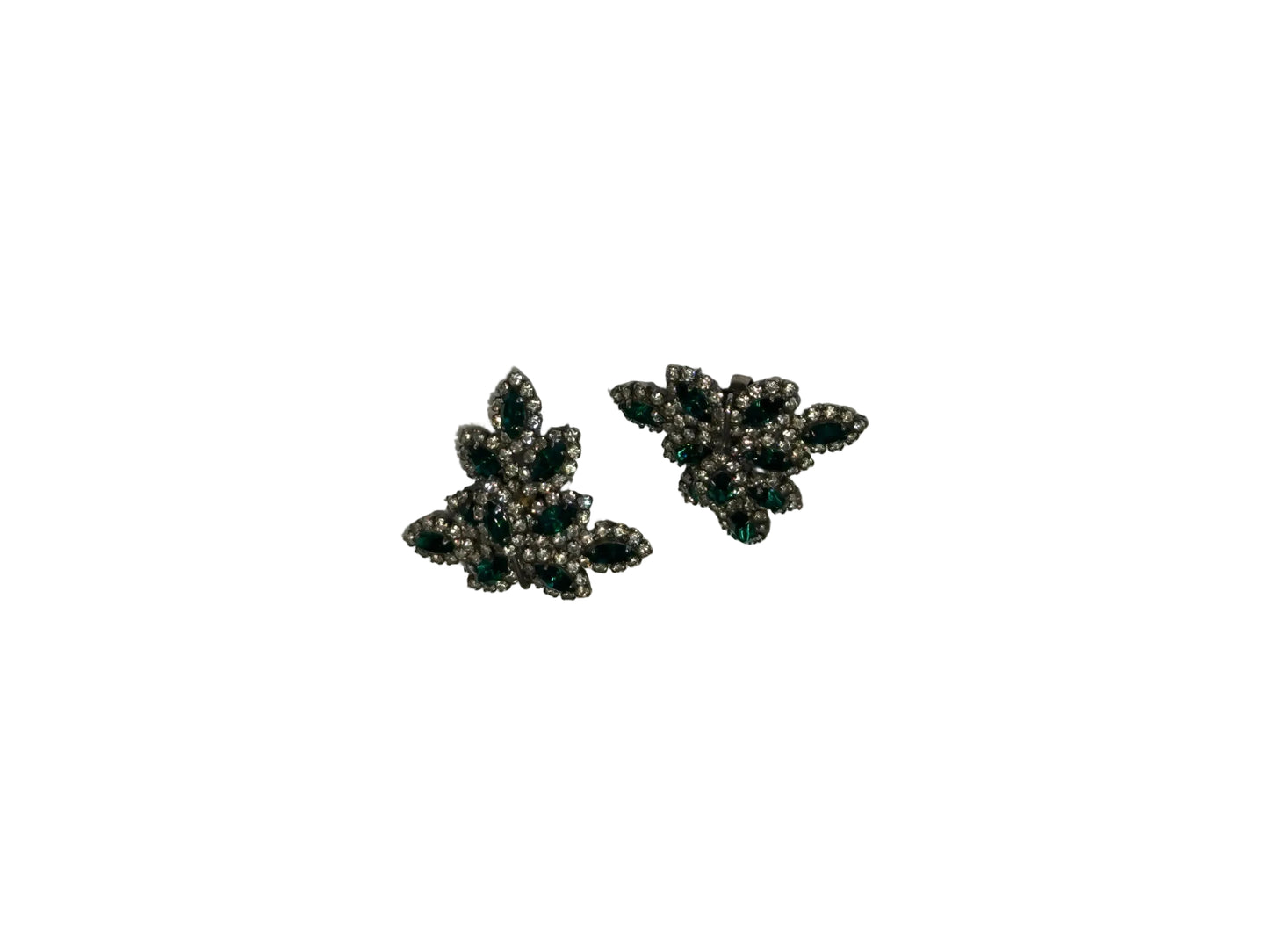 Vintage Les Bernard emerald green and rhinestone leaf-cluster clip earrings, angled view.