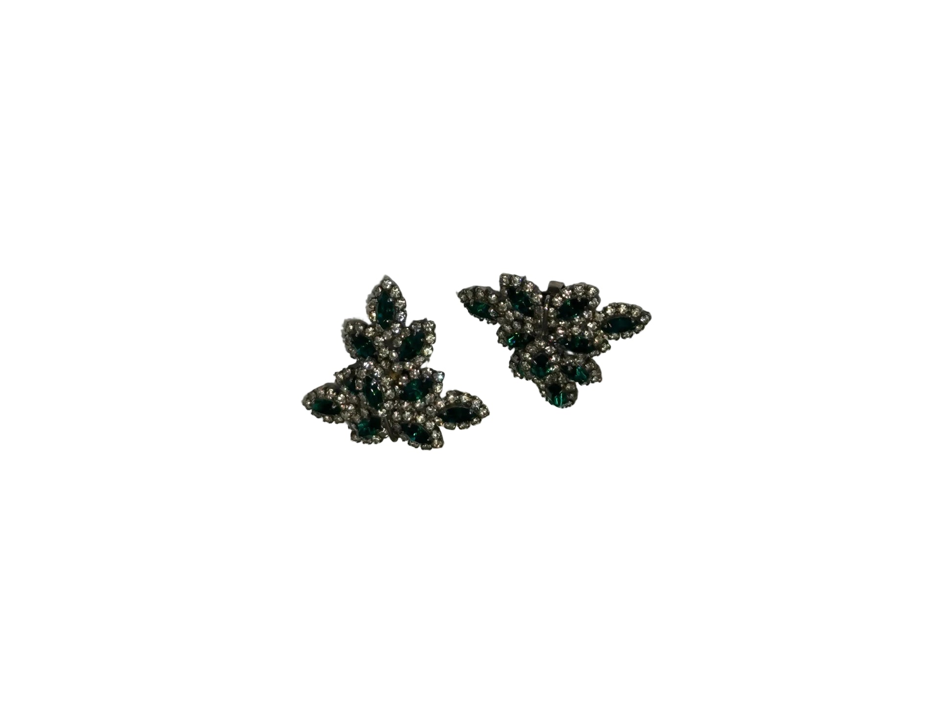 Vintage Les Bernard emerald green and rhinestone leaf-cluster clip earrings, angled view.