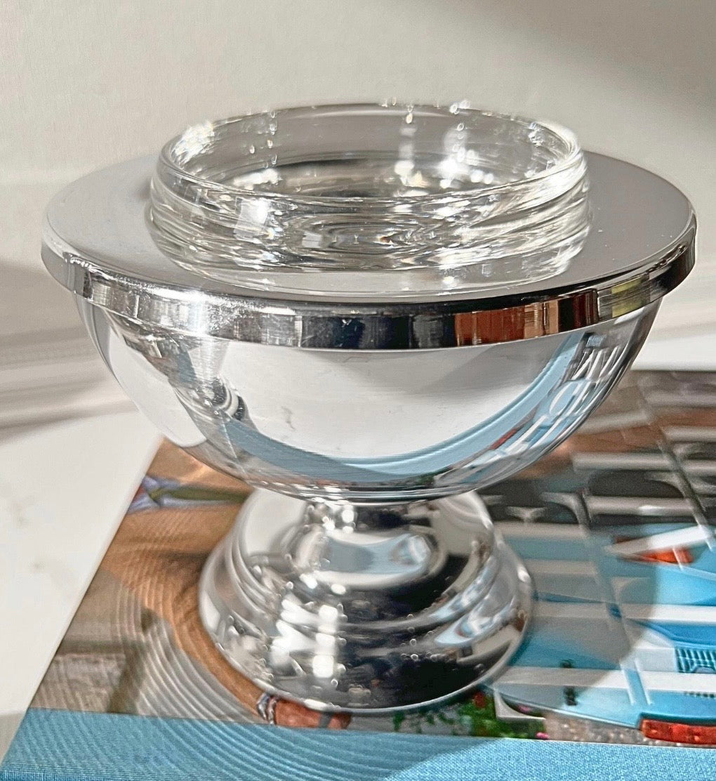 Silver-plate caviar server with glass insert styled on a book, lifestyle view