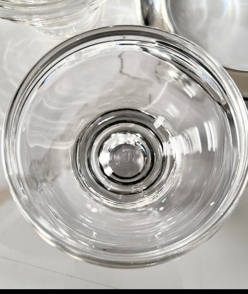Top-down close-up into a caviar server's clear glass insert showing its thick base