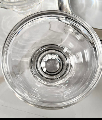 Top-down close-up into a caviar server's clear glass insert showing its thick base
