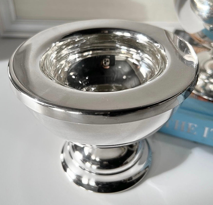 Silver-plate caviar server with clear glass liner seated in wide rim, angled view