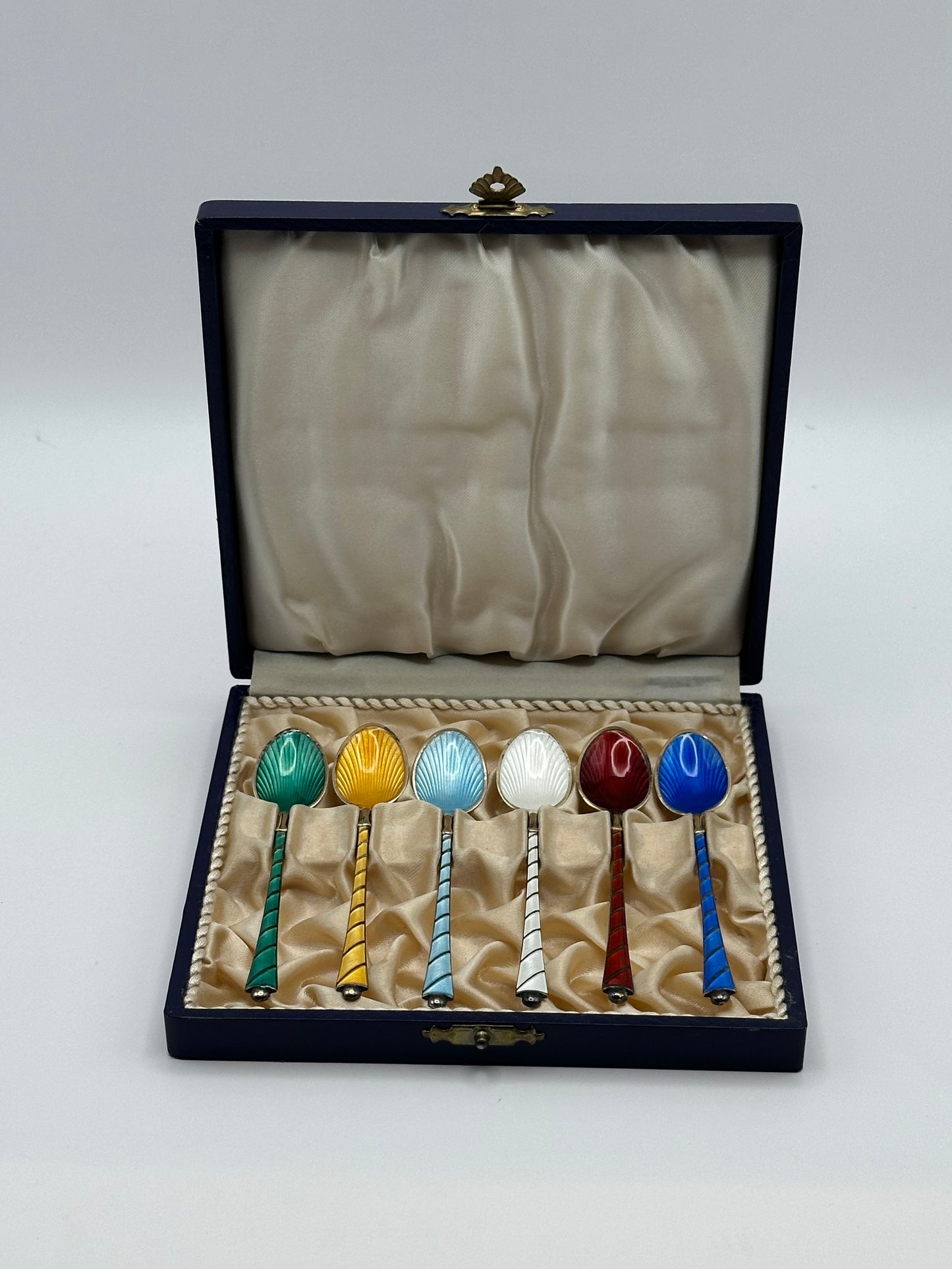 Vintage Ela of Denmark enamel demitasse spoon set of 6 in open navy box, multicolored guilloché bowls, front view.