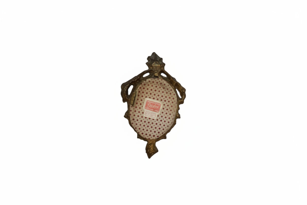 Back of gilt Florentine mirror with red polka-dot paper backing and maker's label.