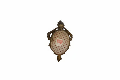 Back of gilt Florentine mirror with red polka-dot paper backing and maker's label.