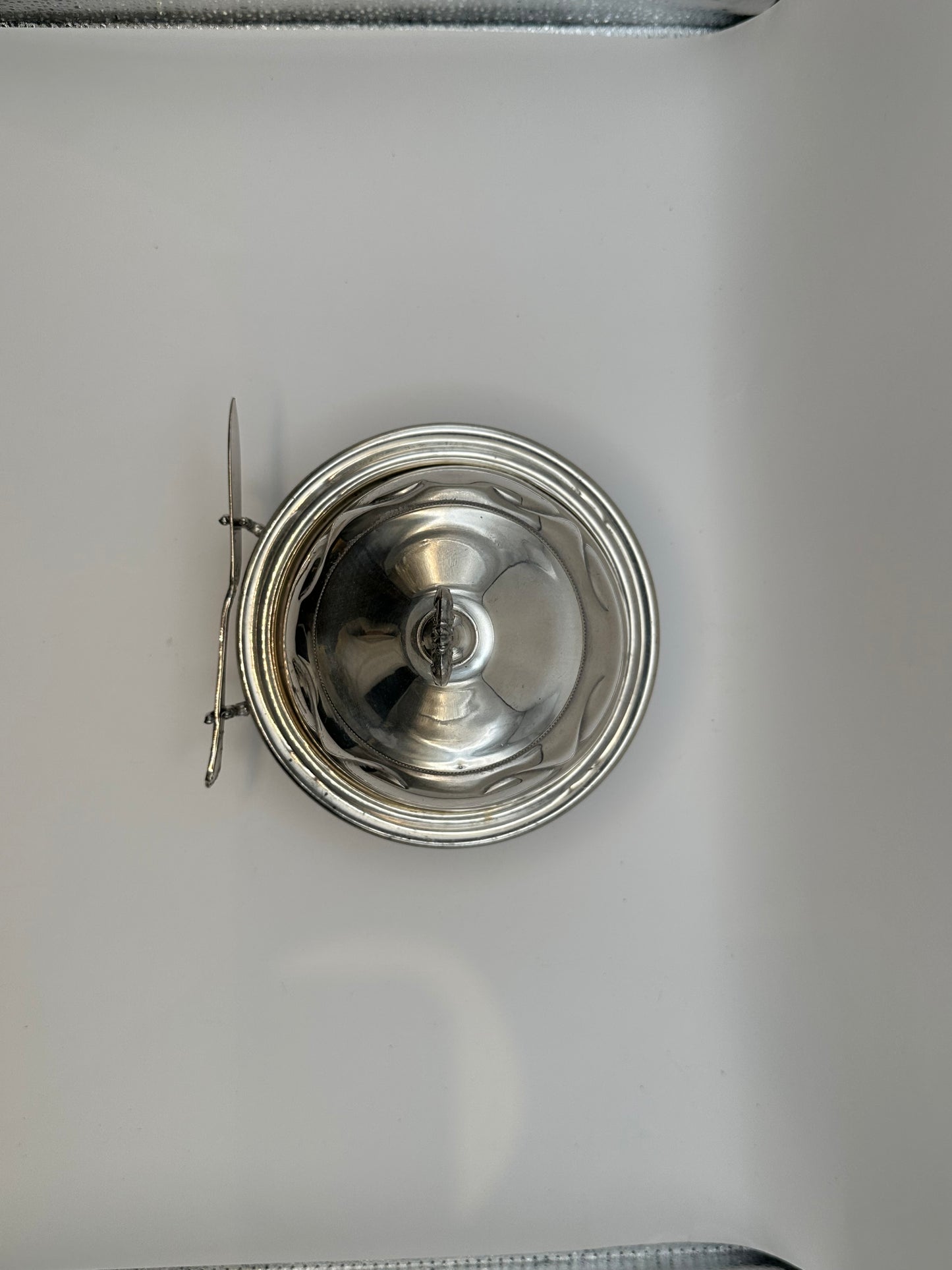 Top view of silverplate caviar dome lid and spreader knife
