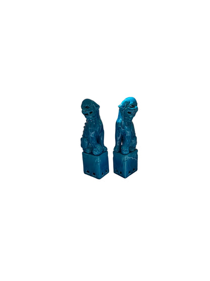 Pair of turquoise glazed ceramic foo dogs, angled three-quarter view on bases