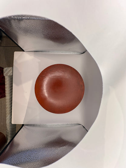 Reddish-brown underside of the round papier-mache box