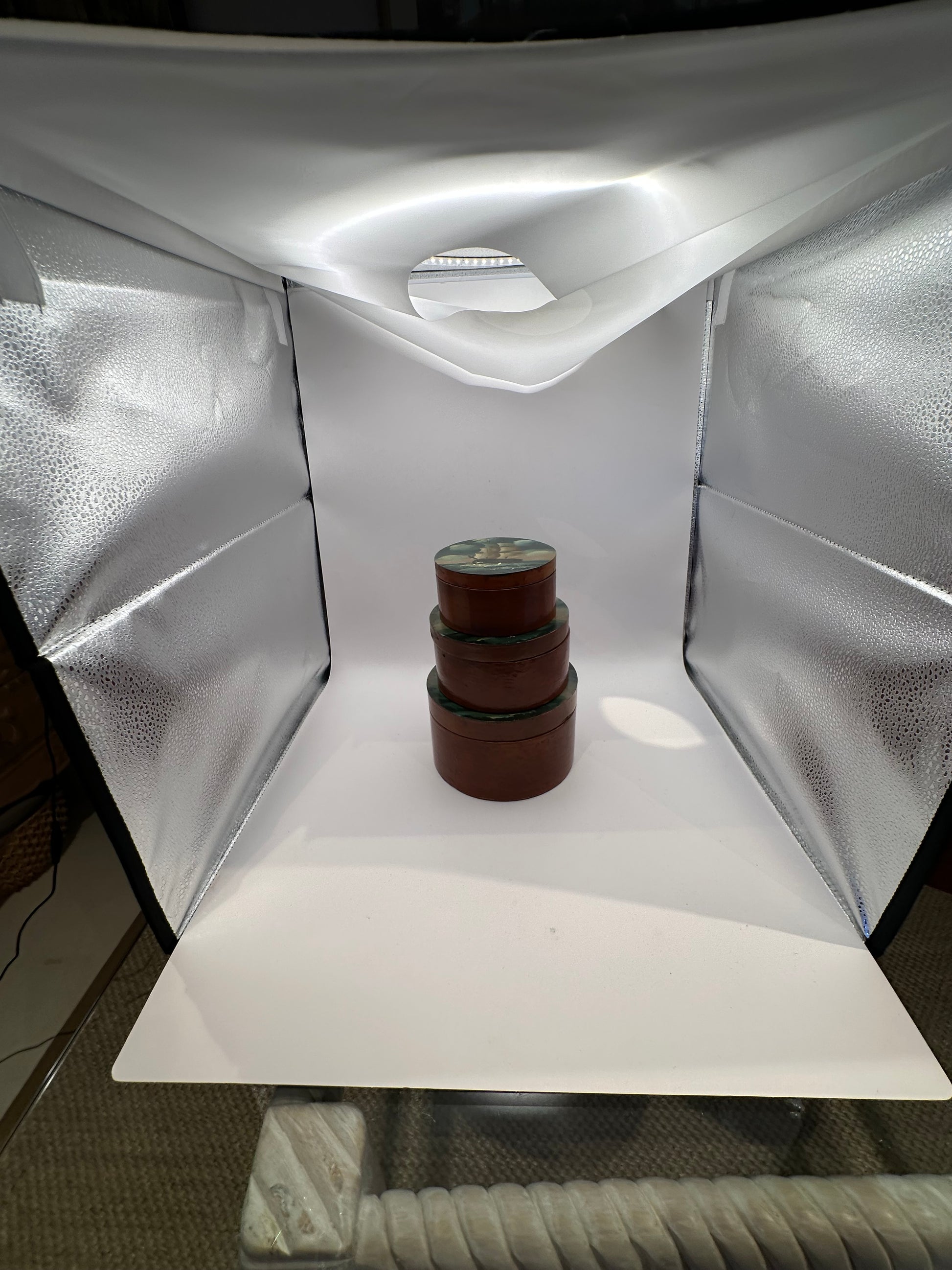 Stacked nest of three round painted papier-mache boxes, smallest on top