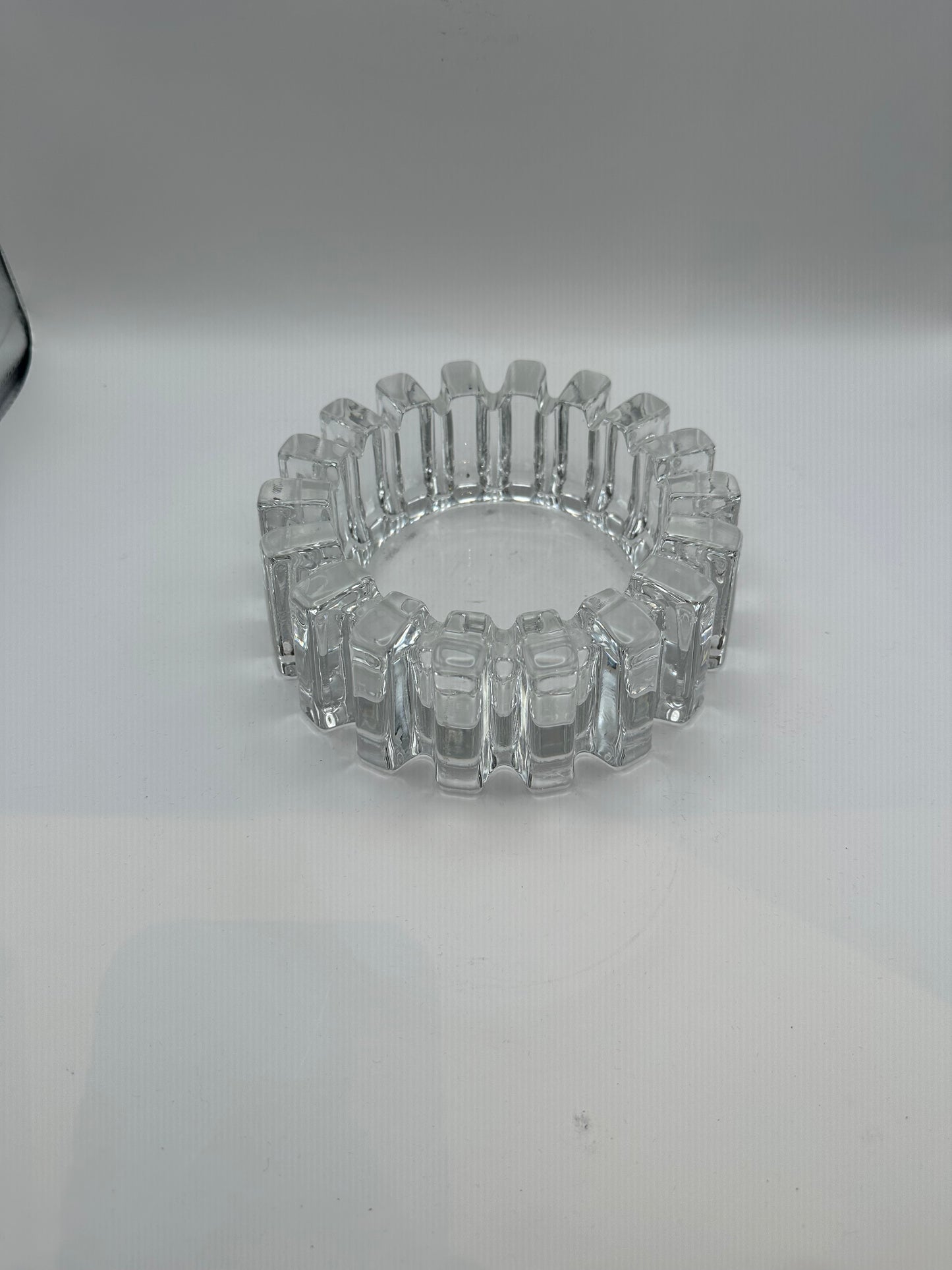 Vintage MCM heavy clear glass dish with blocky notched rim, three-quarter view