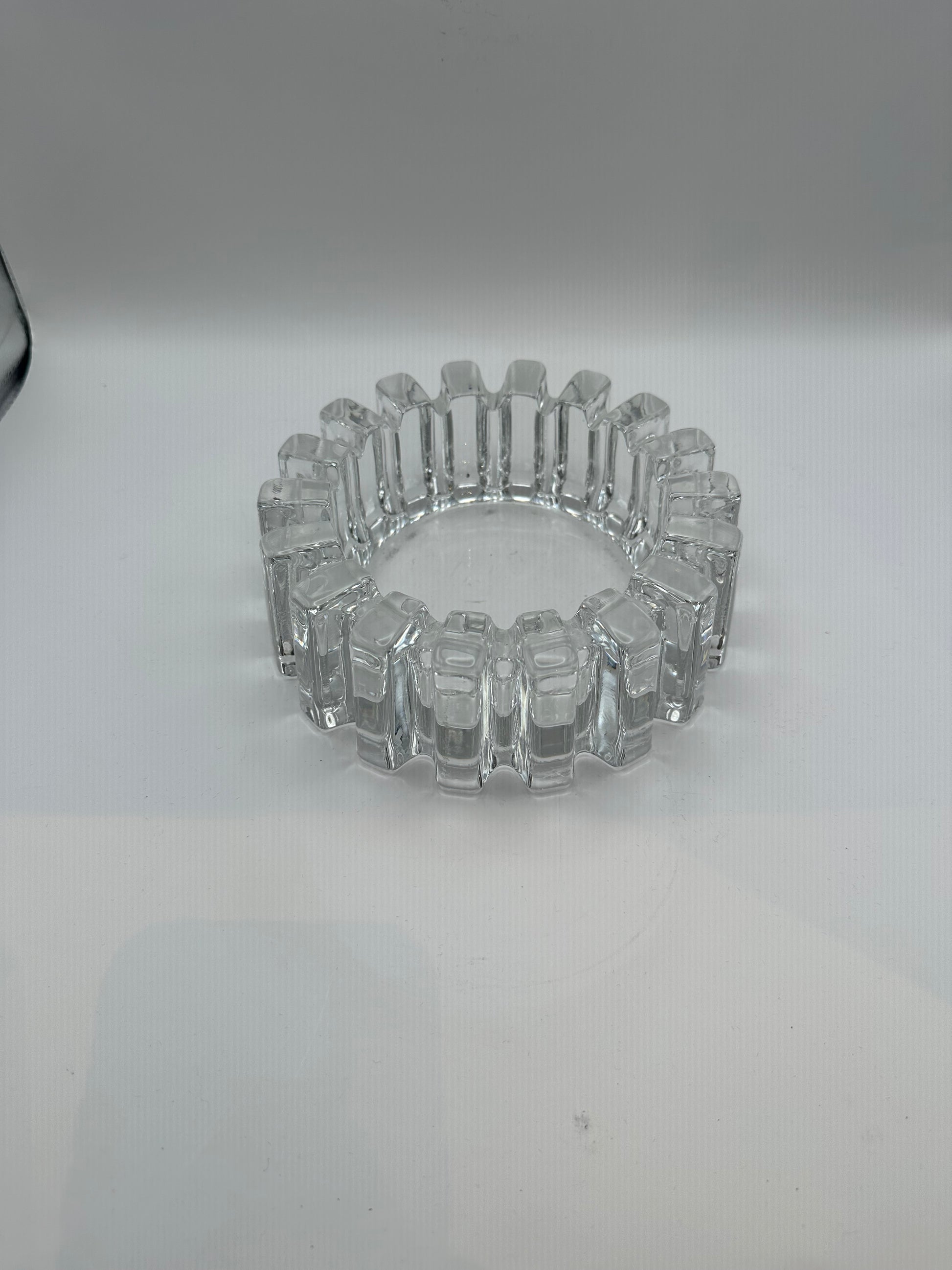 Vintage MCM heavy clear glass dish with blocky notched rim, three-quarter view