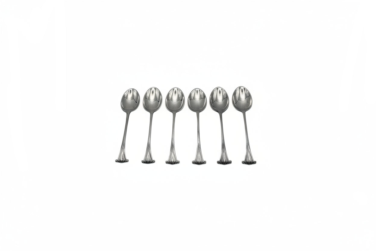 Six silverplate demitasse spoons arranged in a row, bowls up, showing scrolled fan-shaped handle ends