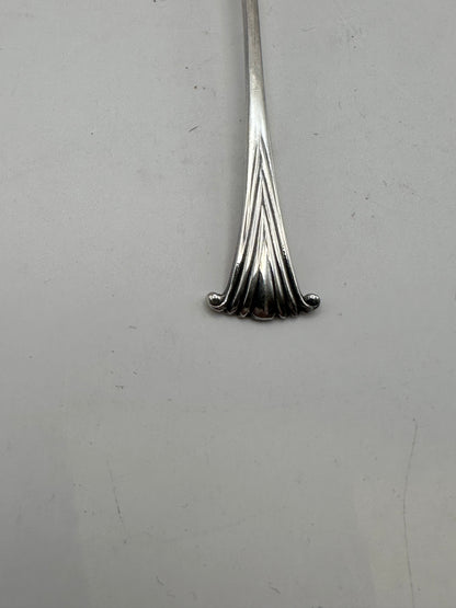 Close-up of the fanned scroll-shell terminal at the end of a silverplate demitasse spoon handle