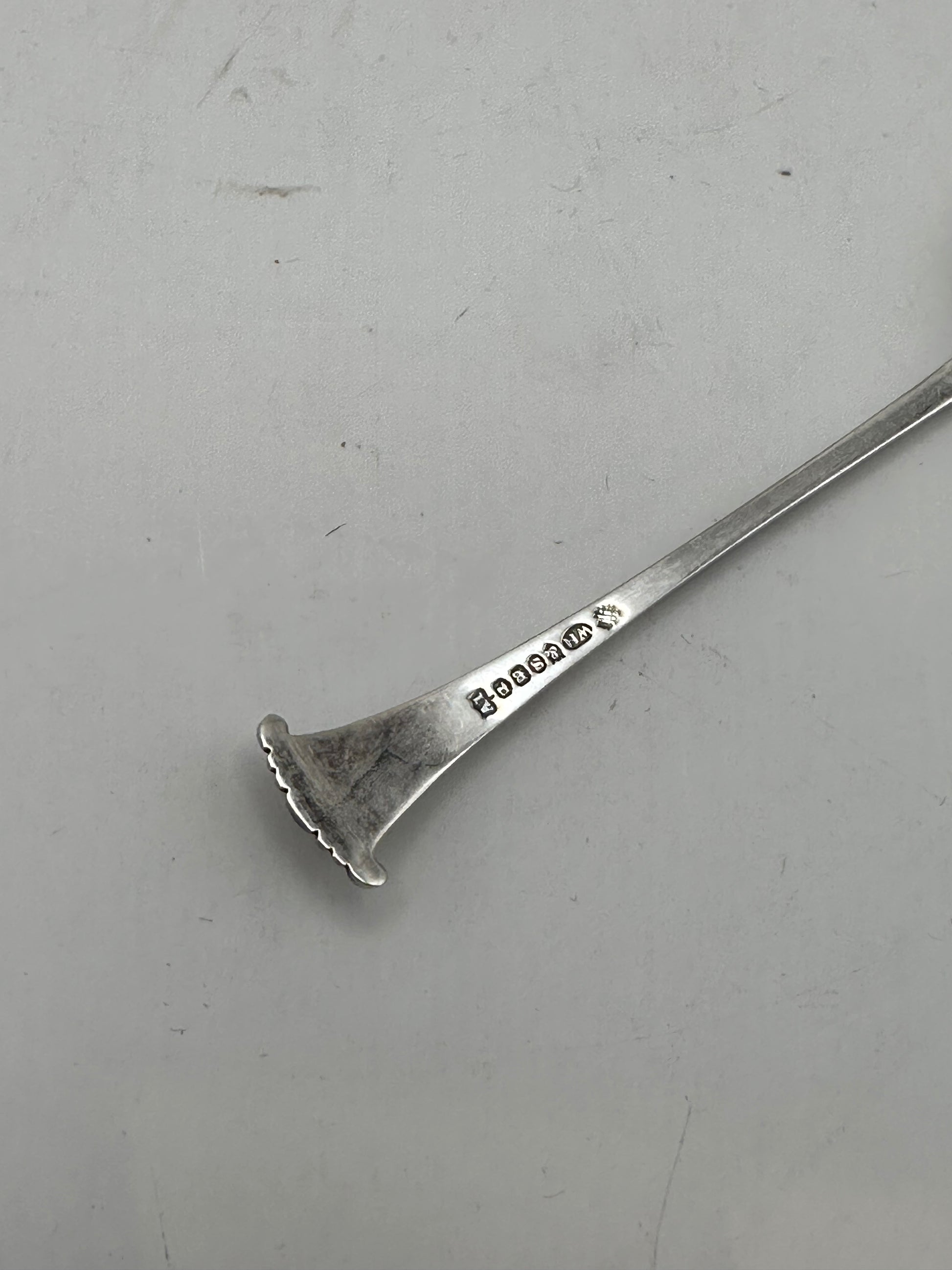 Back of a demitasse spoon handle terminal showing hallmark stamps along the silverplate stem