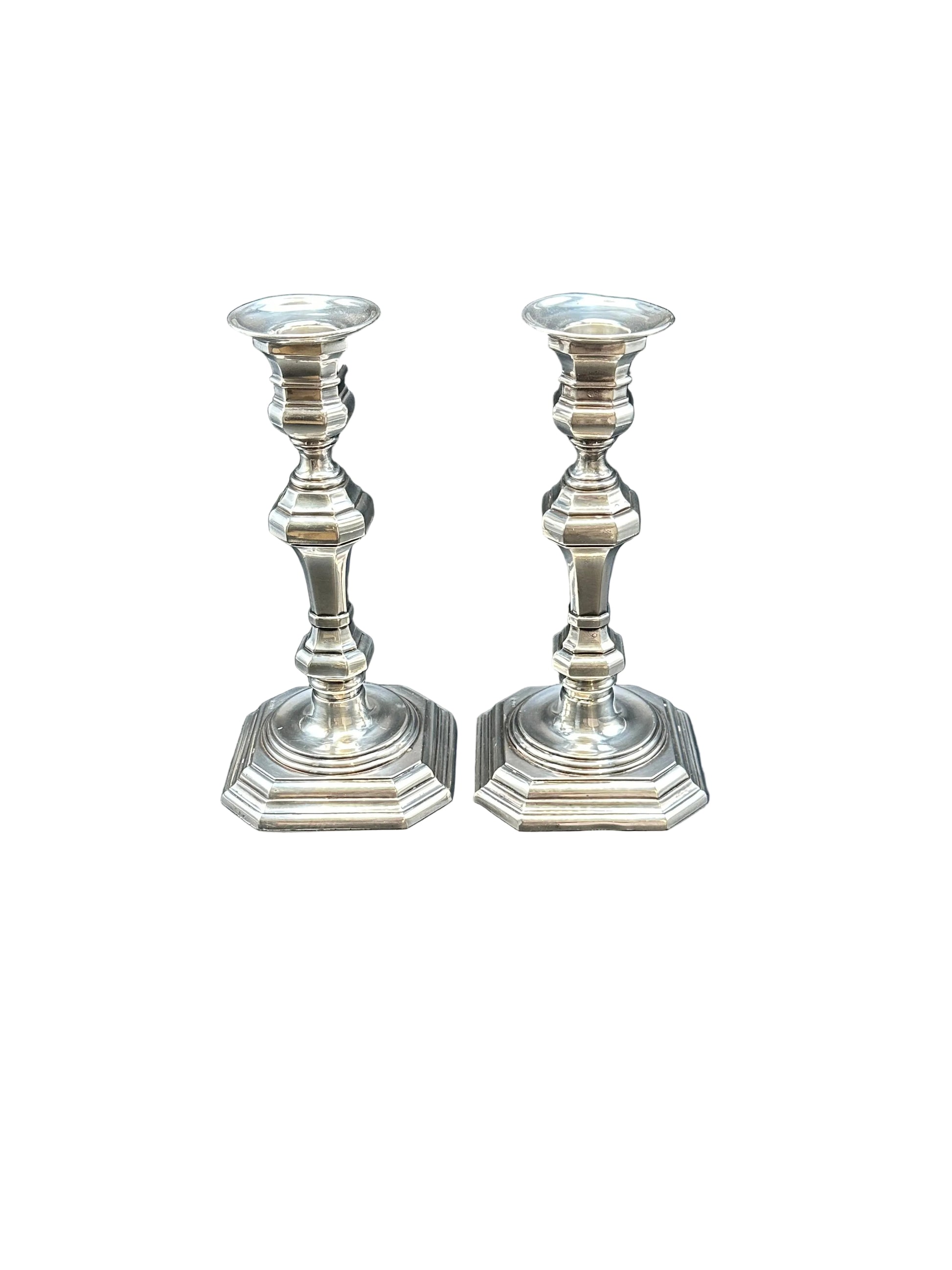 Pair of Georgian Revival silver plate candlesticks with octagonal bases and baluster stems, on white