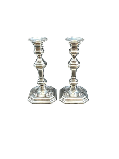 Pair of Georgian Revival silver plate candlesticks with octagonal bases and baluster stems, on white