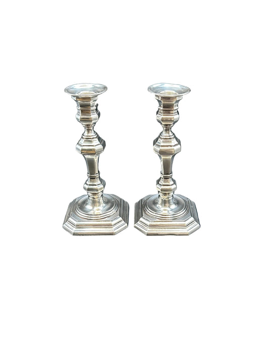 Pair of Georgian Revival silver plate candlesticks with octagonal bases and baluster stems, on white