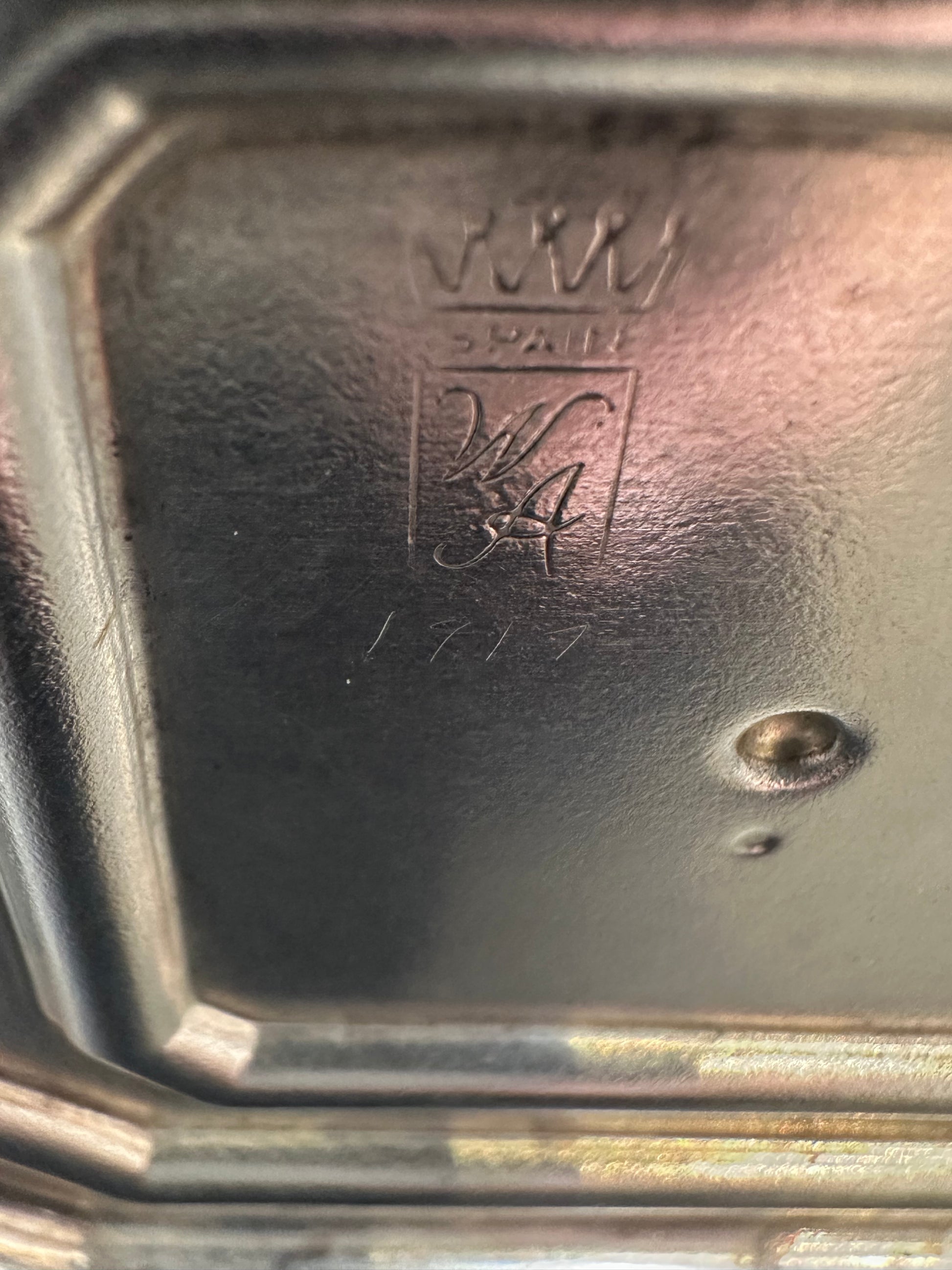 Close-up of candlestick base showing crowned Spain hallmark and engraved W.A. monogram