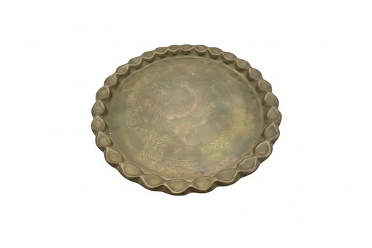 Vintage brass hammered tray with scalloped rim and engraved dragon center, angled view on white