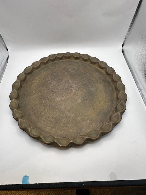 Vintage brass hammered tray with scalloped edge, top view in a photo light box