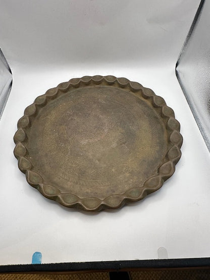 Vintage brass hammered tray with scalloped edge, top view in a photo light box