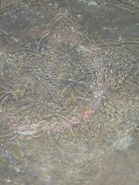 Close-up of vintage brass tray center showing engraved dragon and foliate detailing