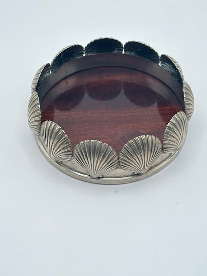 Angled view of MCM scallop shell silverplate bottle coaster with wood base
