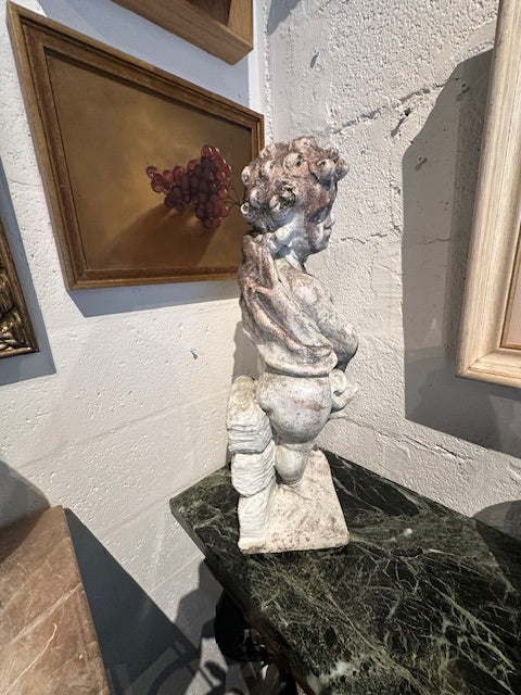 Concrete "Winter" cherub statue with draped blanket, front view in situ on marble tabletop