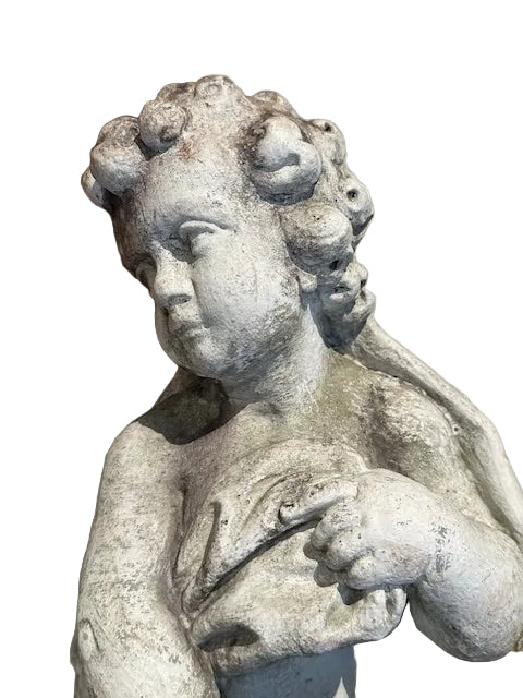 Close-up of concrete Four Seasons cherub statue head and torso showing curls and aged surface