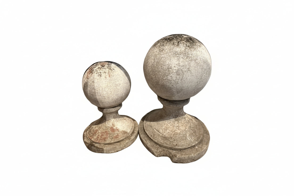Pair of vintage concrete garden spheres on molded bases, weathered patina, different sizes, side by side