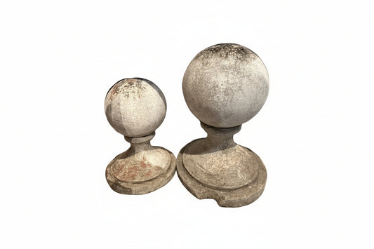 Pair of vintage concrete garden spheres on molded bases, weathered patina, different sizes, side by side
