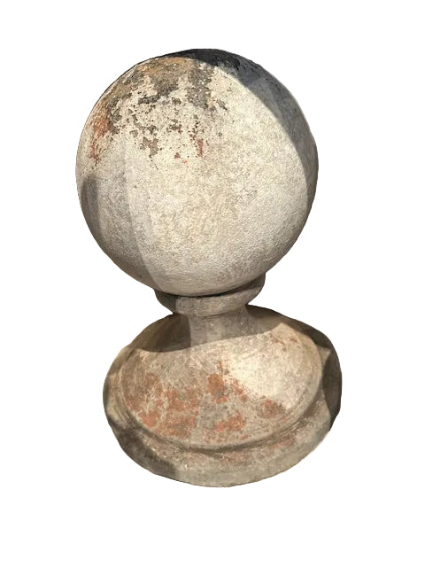 Angled view of one concrete garden sphere on molded base showing mottled aged surface