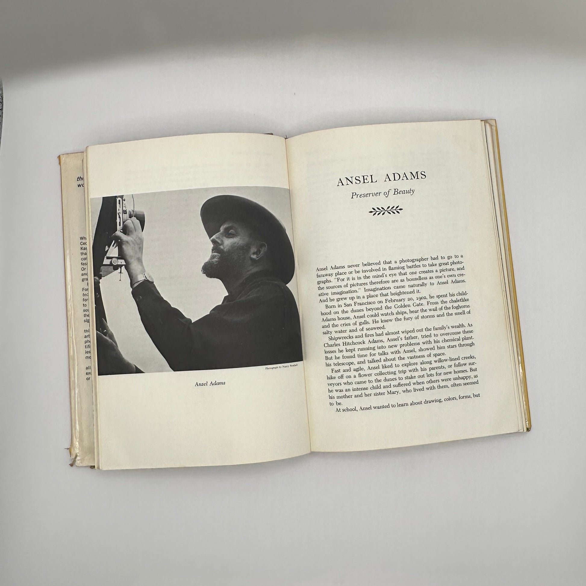 Open book to Ansel Adams chapter, "Preserver of Beauty," with black-and-white portrait photo