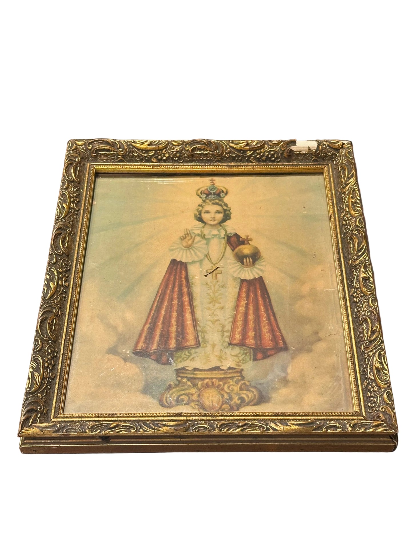 Vintage framed "Infant Jesus of Prague" print, crowned child holding orb, in ornate gilt wood frame, angled front view